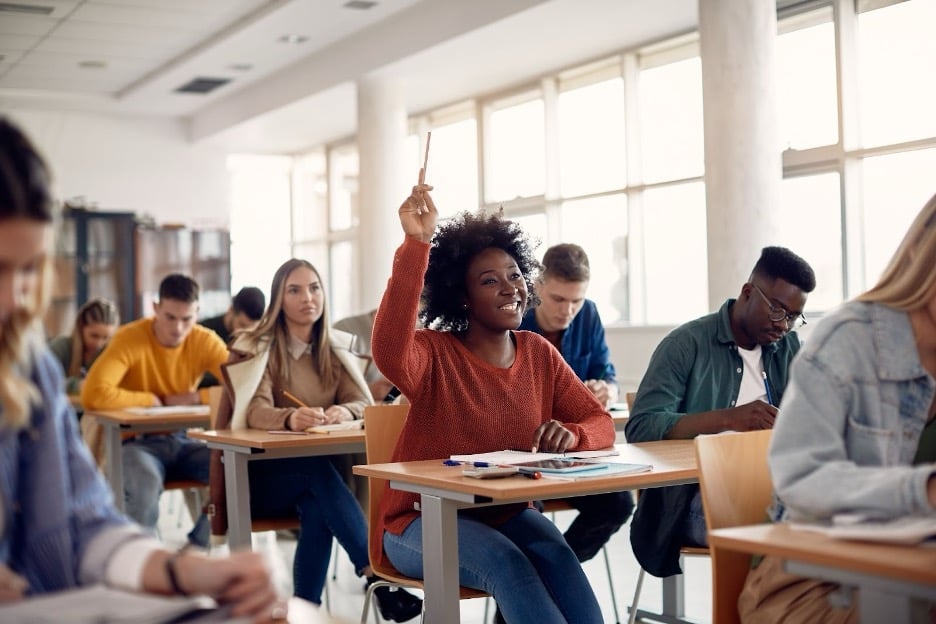 A student raising her hand at school.
