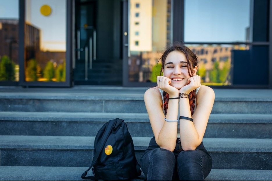 Girl sitting on steps outside.